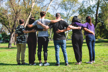 Rear view of a group of hugging friends. Friendship and support concept.