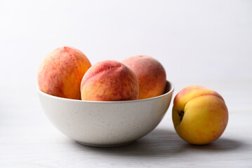 Ripe Peaches fruit in bowl on white table