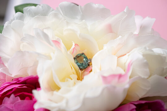 Wedding ring with a large blue topaz in peonies. Wedding jewelry composition.