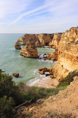 Fototapeta na wymiar Small beach surrounded by limestone cliffs along the Seven Hanging Valleys Trail in Algarve, Portugal on a winter day.