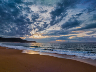 Sunrise seascape with clouds and gentle surf