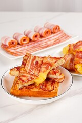 Bacon in a plate, bacon pork rolls in various recipes, on a white kitchen tabletop, indoor scene