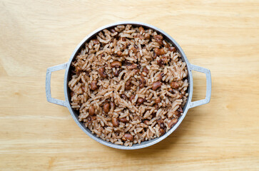 A rustic bowl of rice and beans nestled on a wooden backdrop