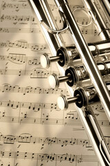 Trumpet on musical notes as background close up