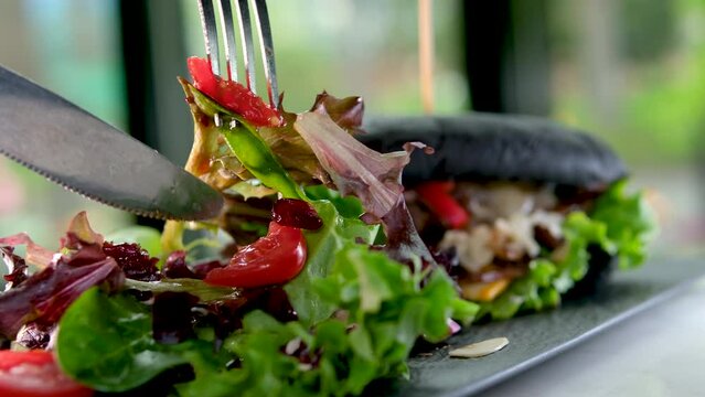 fork and knife eat salad in a restaurant delicious appetizing lunch dinner lunch rest relaxation awesome food burger in black cuttlefish ink bun beautiful serving