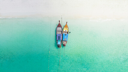 KOH LIPE, High aerial view of long tail boats with clear blue water in sunny day at sunrise beach, attraction activity of trip swimming and snorkelling on LIPE island, satun, near phuket, Thailand.