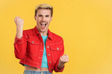 Happy gay man celebrating while raising fists