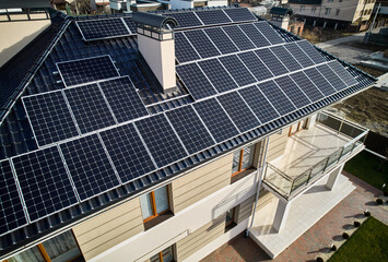 Residential house with solar modules for generating electricity through photovoltaic effect. Home...