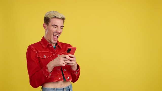 Happy gay man smiling while using the mobile