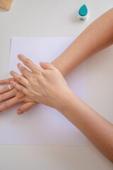top view of a woman's hands pressing a rubber stamp on a blank sheet of paper.