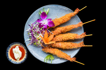 Fried shrimps in batter with red sauce isolated on black background top view - obrazy, fototapety, plakaty