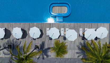 Aerial Top view of Exterior design  Luxury swimming pool with white fashion deckchairs on the beach