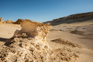 Barren desert landscape in hot climate with eroded rock formation