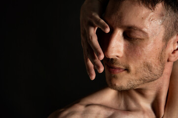 Naklejka premium Young attractive man with an athletic body on a black background.