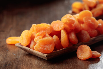 Dried apricots in a wooden dish.