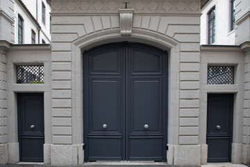 grey wooden front door of street restored house entrance dark gray classic gate