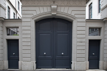 grey wooden front door of street restored house entrance dark gray classic gate