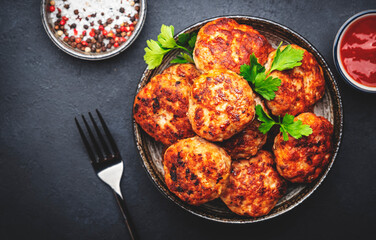Homemade fried pork and beef meatballs in ceramic bowl, dark table background, top view