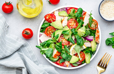 Chicken and vegetables salad with tomatoes,  avocado, cucumber, onion, lamb lettuce and sesame...