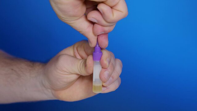 Male breaks off tip from lid of dropper bottle filled with urine for self-testing