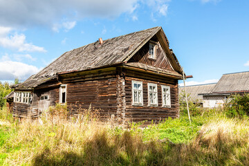 Fototapeta na wymiar Old abandoned rural wooden house in russian village in summer sunny day