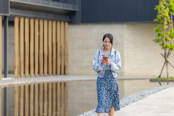 Woman walk in the street with her phone