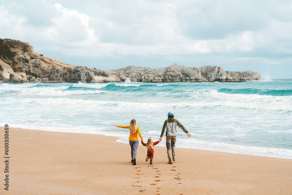 Wall mural Family mother and father with child walking together outdoor travel lifestyle vacations parents with kid holding hands on the beach happy emotions sea landscape