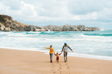 Family mother and father with child walking together outdoor travel lifestyle vacations parents with kid holding hands on the beach happy emotions sea landscape