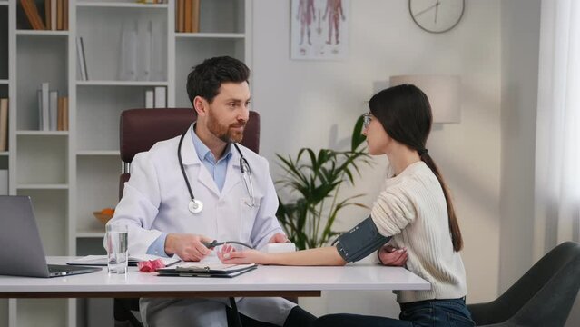 Blood pressure measurement. With woman. Doctor in formal clothes is working in the cabinet.