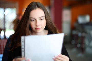 Fototapeta premium Serious woman reading menu in a restaurant
