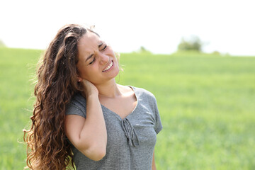 Naklejka premium Woman suffering neck ache in a field