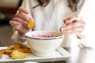 Obraz na płótnie Canvas Woman ready to eat delicious fried potatoes with soup