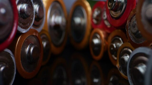 Close-up shot of old alkaline batteries, commonly known as "AA" or "AAA". Captured in macro against a dark background.
