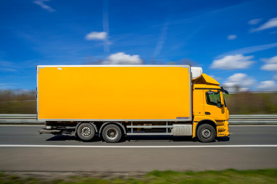Germany, North Rhine Westphalia, Yellow truck driving along A 46