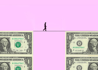 Silhouette of woman walking tightrope between two blocks made of one dollar bills