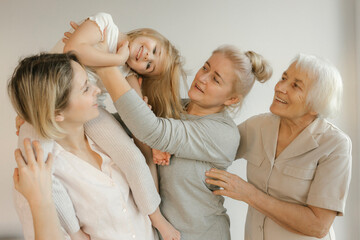 Woman carrying girl on shoulder by grandmother at home