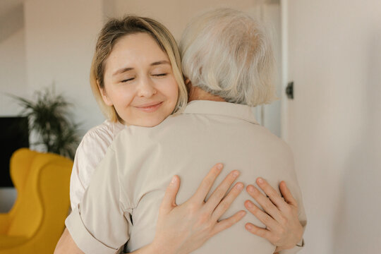 Smiling woman embracing grandmother at home
