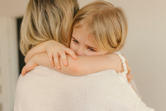 Sad daughter embracing mother at home