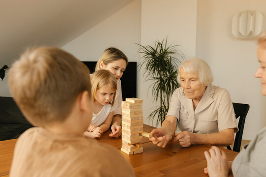 Elderly woman playing game with family at home