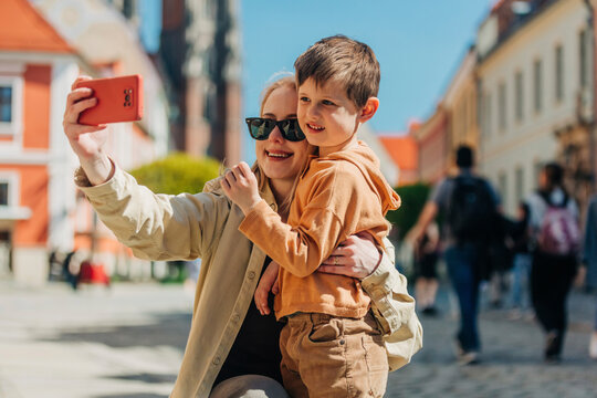 Mother taking selfie with son through smart phone at vacation