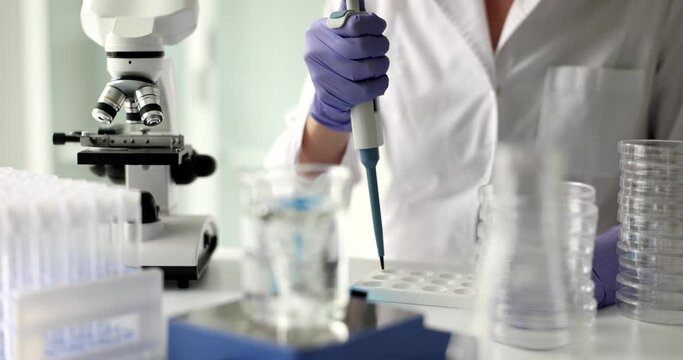 Laboratory assistant conducts professional examinations of liquid sample. Checking quality of water in lab