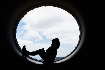 silhouette of a happy child at a round window