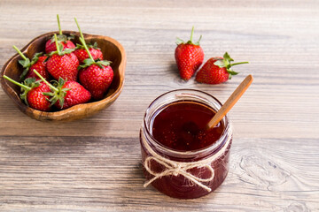 Natural strawberry jam with ripe strawberries on wooden table