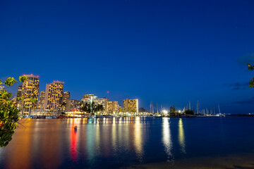 Fototapeta na wymiar Waikiki Skyline at Night with Reflections on the Water