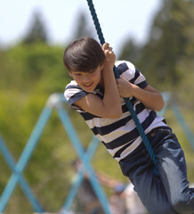 a young boy swinging on a rope