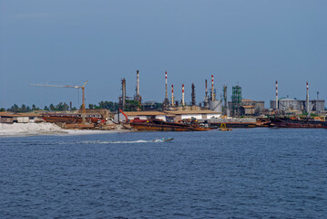 A Local Open Fishing Boat speeding out to sea passing by the Pointe Clairette Petrochemical Complex...