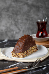 Banana and chocolate cream cake. Chocolate covered and hazelnut malaga cake on a dark background.