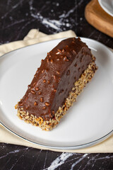 Banana and chocolate cream cake. Chocolate covered and hazelnut malaga cake on a dark background. Close up