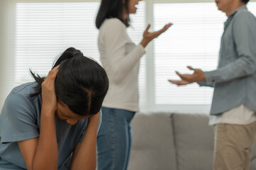 Fototapeta premium problem in family. daughter use hands cover your face and feel stressed from the parents quarrel. child is have mental problem. quarrels, violence, depression, suicide, discouragement, social problem