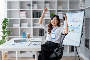 Happy asian businesswoman raising hands with victory smiling happily with smart phone. The concept of success at work.